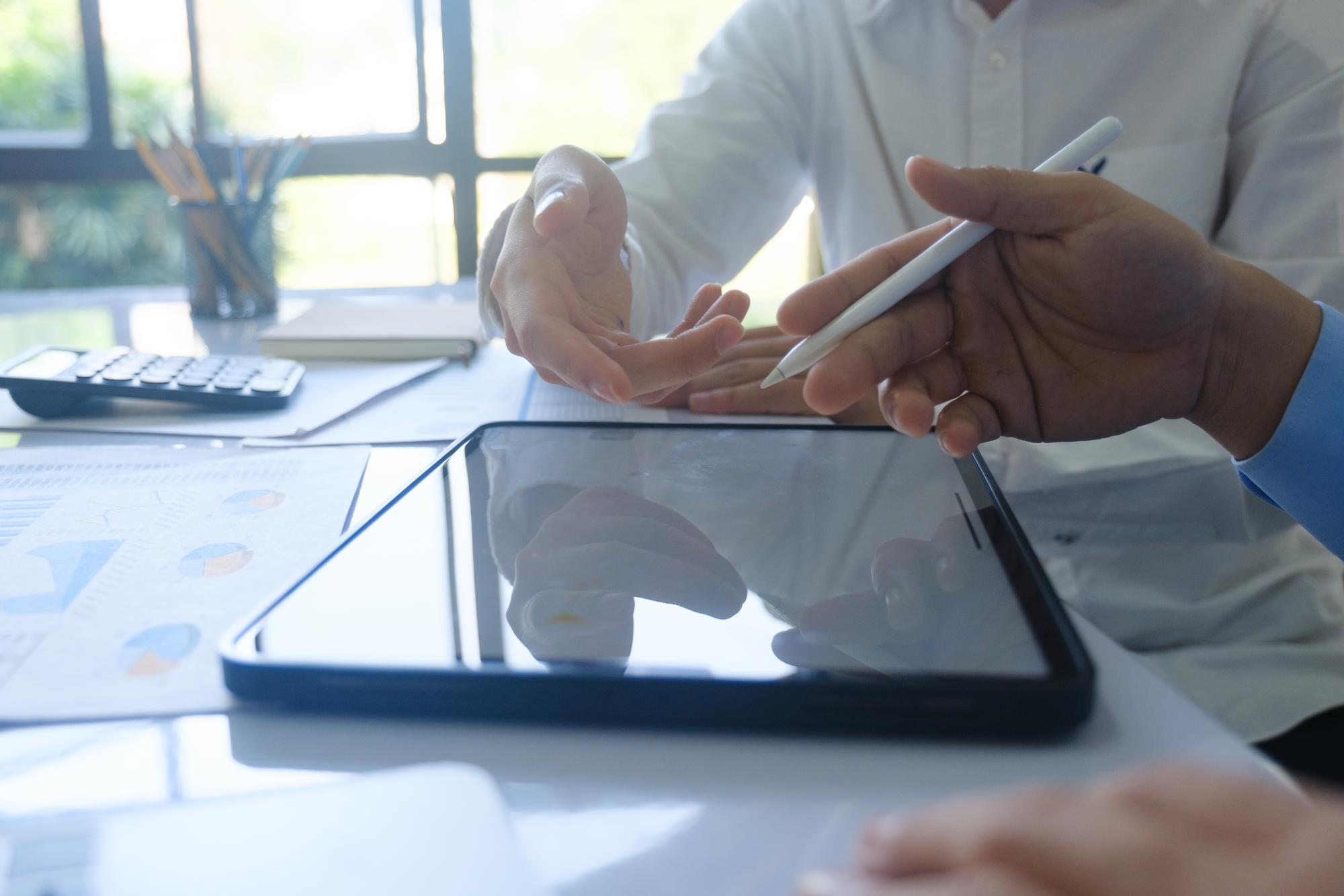 Beraterin erklärt Finanzplan an Tablet